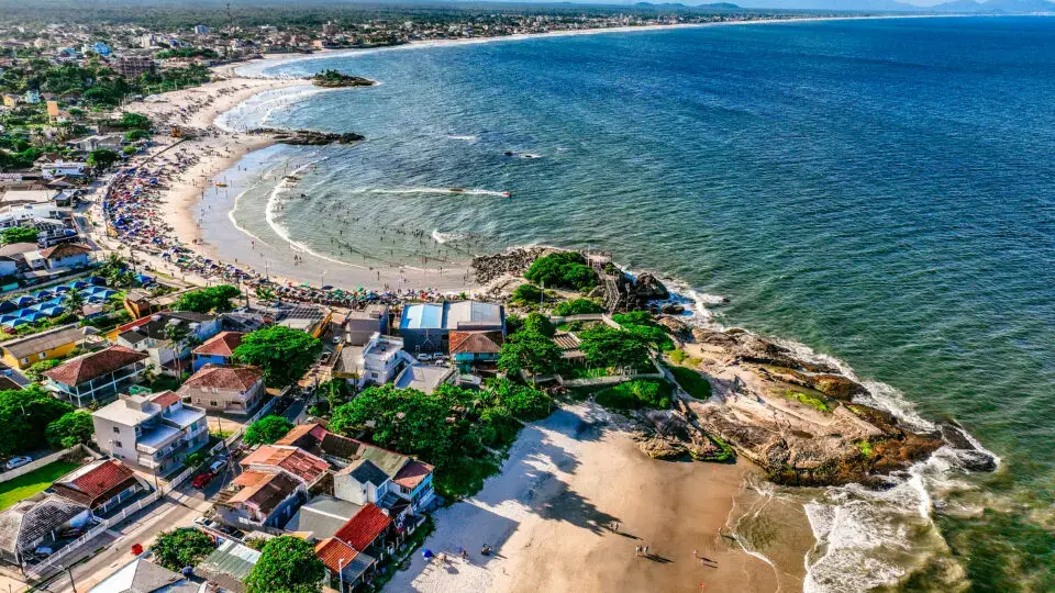 Imagem aérea de praia de Itapoá, com vista do mar, area e bairro.